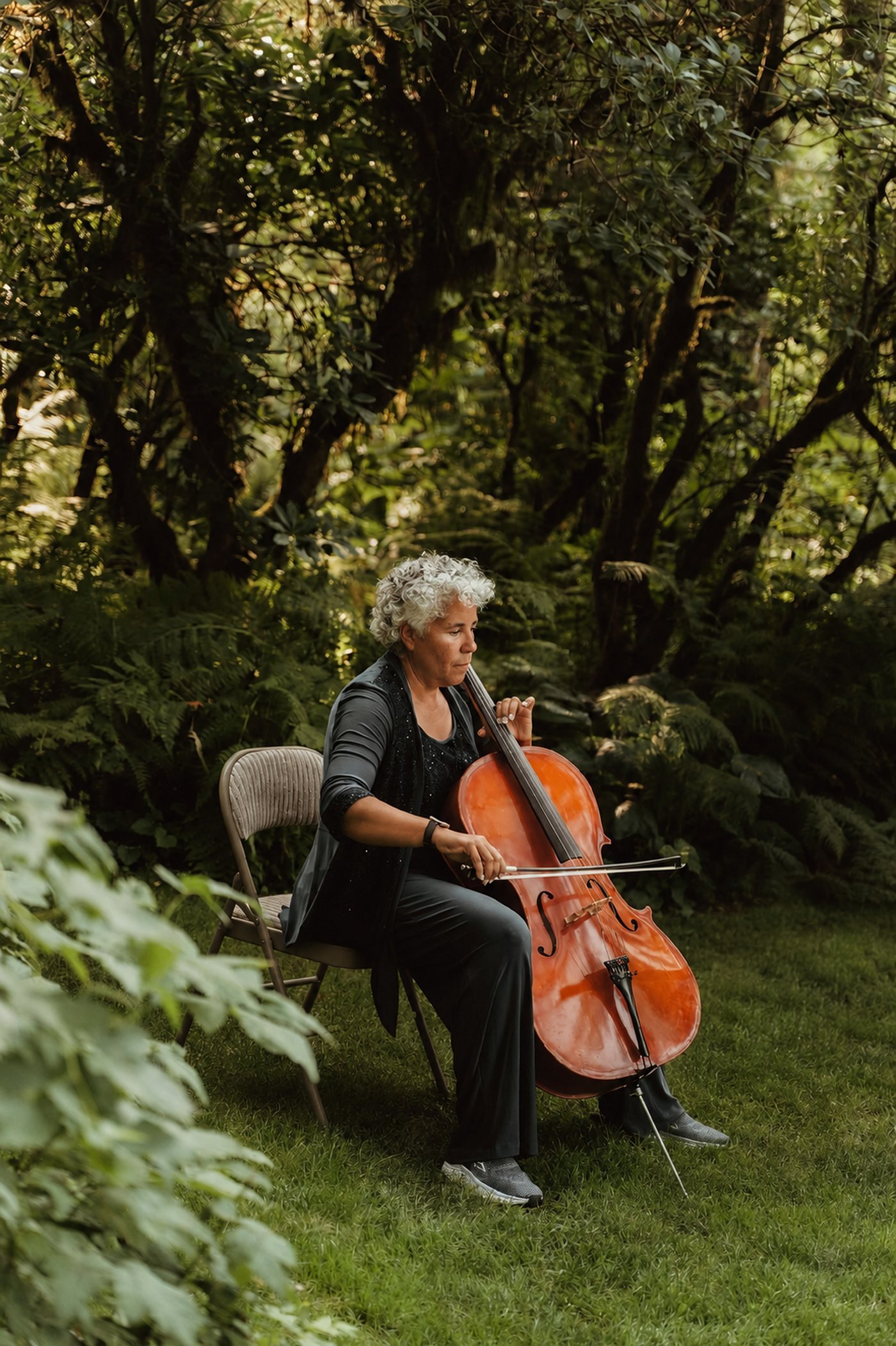 Leanne Felzien performing cello outdoors in a forest setting